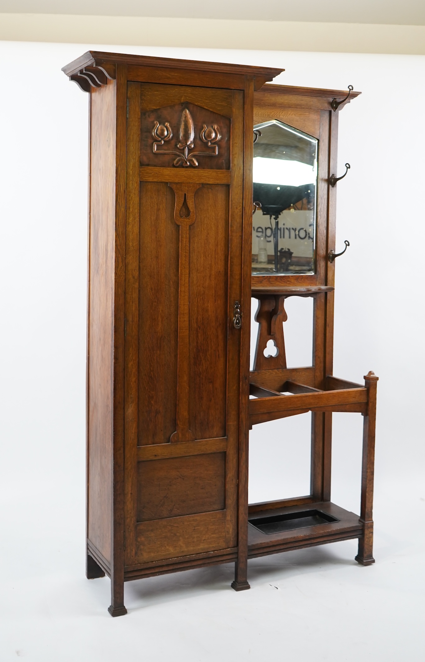 Manner of Liberty & Co: An Arts and Crafts embossed copper mounted oak hall cupboard